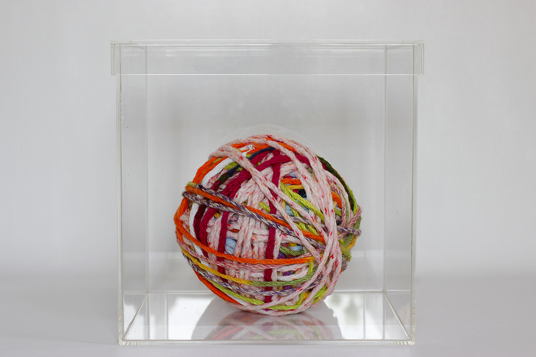 Boule de tricotin sous vitrine. Projet Tricotinages, Viviane Rabaud, art participatif, Colmar