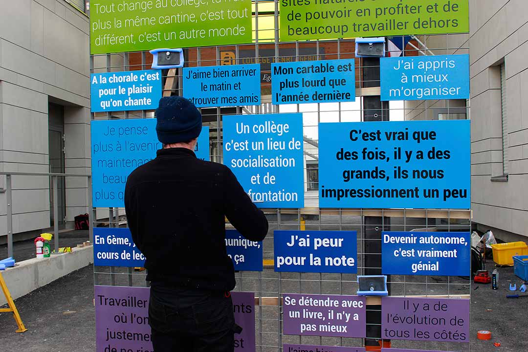 Sitting Tour. Détail affiche sur panneau éléctoral. Portrait de dos avec chaise et laine jaune sur la tête. Mantes-la-Jolie. Art participatif, Viviane Rabaud