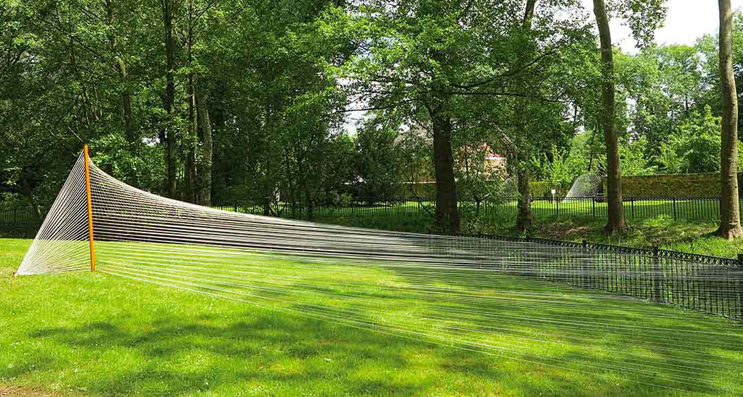 libération du tapis, parc de l'oseraie, les mureaux. Installation filaire in-situ, fils de chaine tendus entre un piquet de bois et les balustrades du parc. Art participatif, Viviane Rabaud