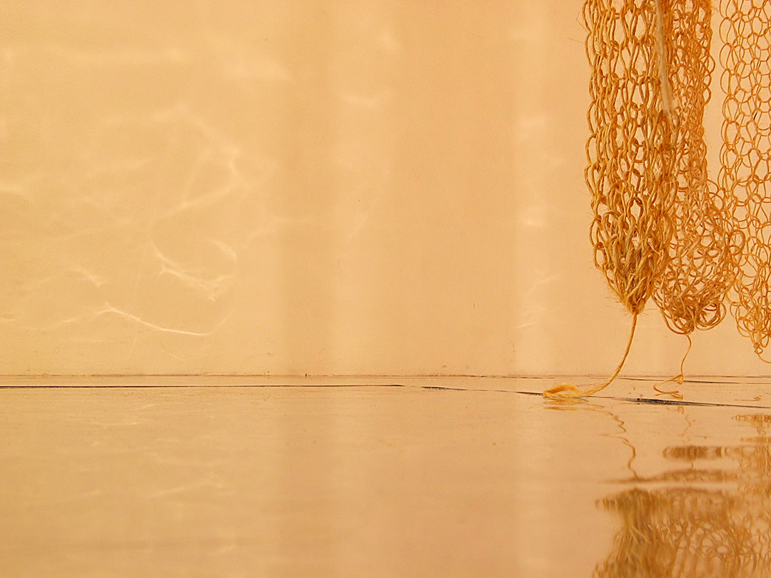 Installation textile, Viviane Rabaud - Centre Art le Colombier, Rennes. Tricotins géants de ficelle sisal descendant du plafond. Sol en plaques d'acier brillantes. Détail