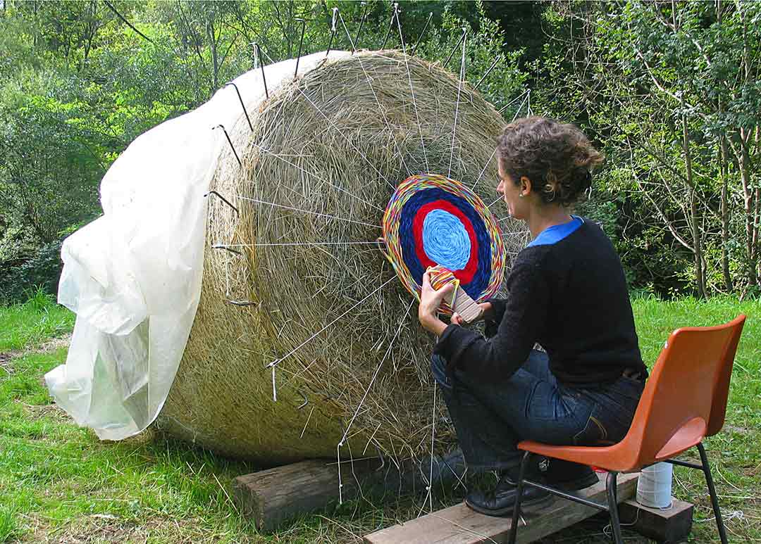 Moi-sonner, Vue de la balle de foin, artiste en train de réaliser le tapis de laine. Oeuvre Viviane Rabaud - Art participatif